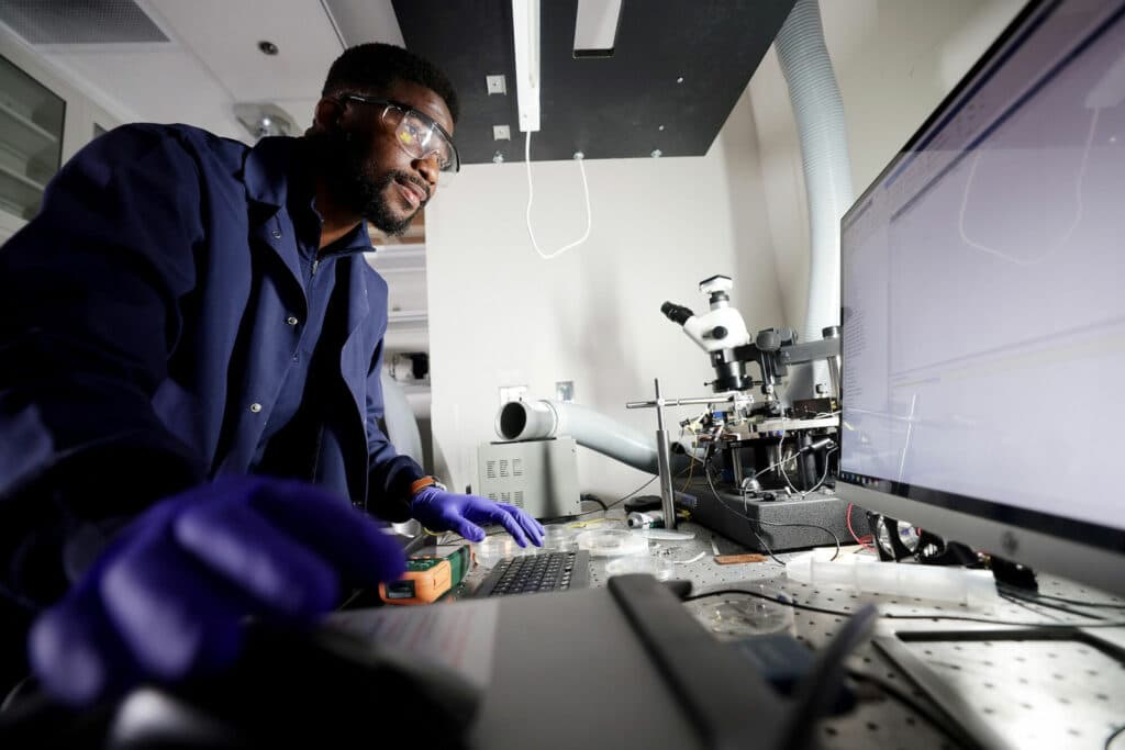 Bosun Roy-Layinde, a recent PhD graduate of chemical engineering, demonstrates how he measures the amount of power generated by his thermal photovoltaic cells.